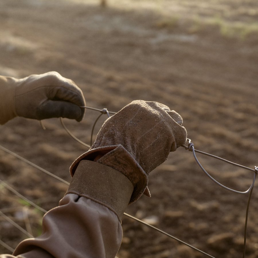 A man fixing fence at dusk